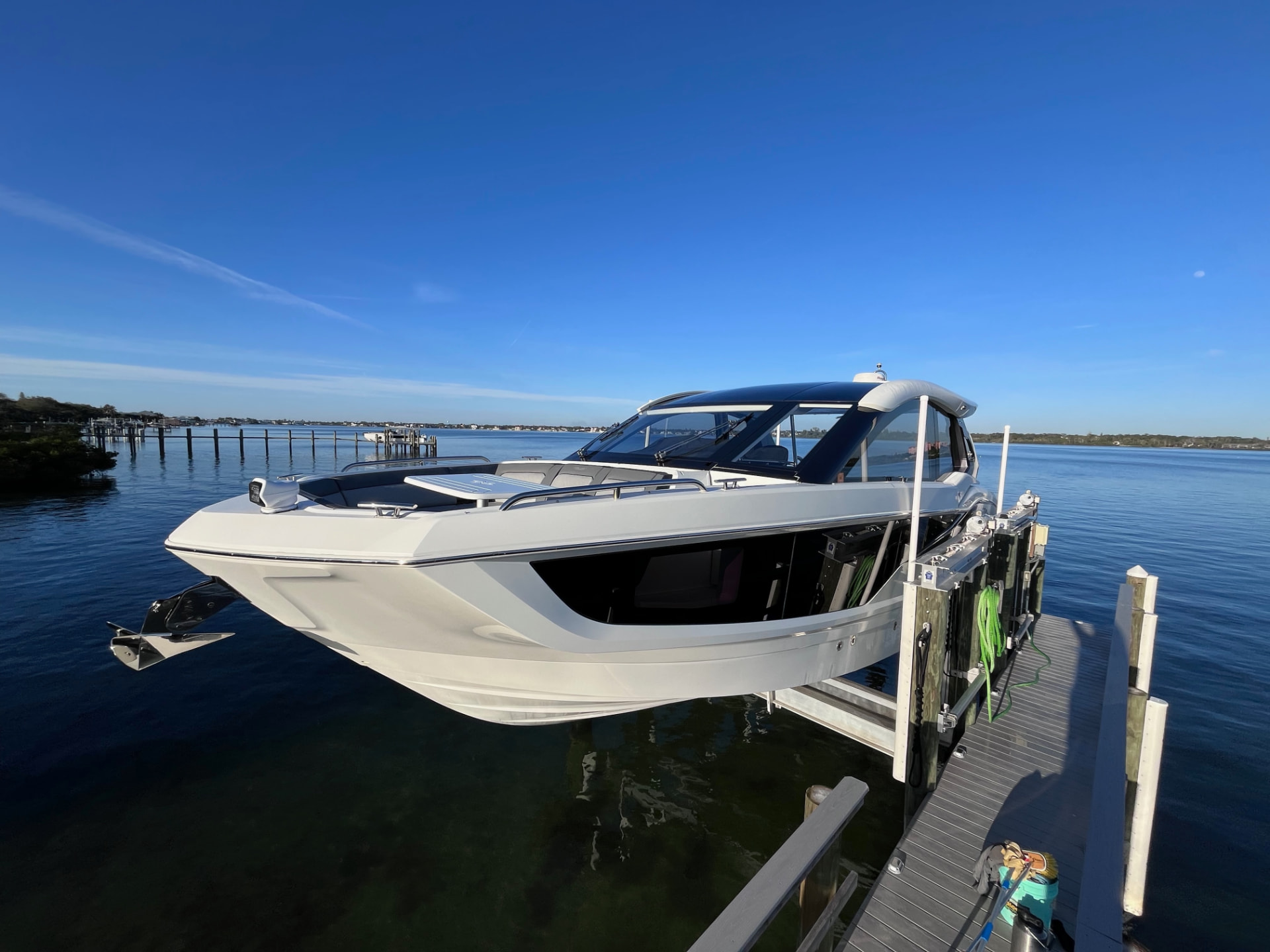 Express cruiser alongside a dock on the Intracoastal with open water astern, ready to run