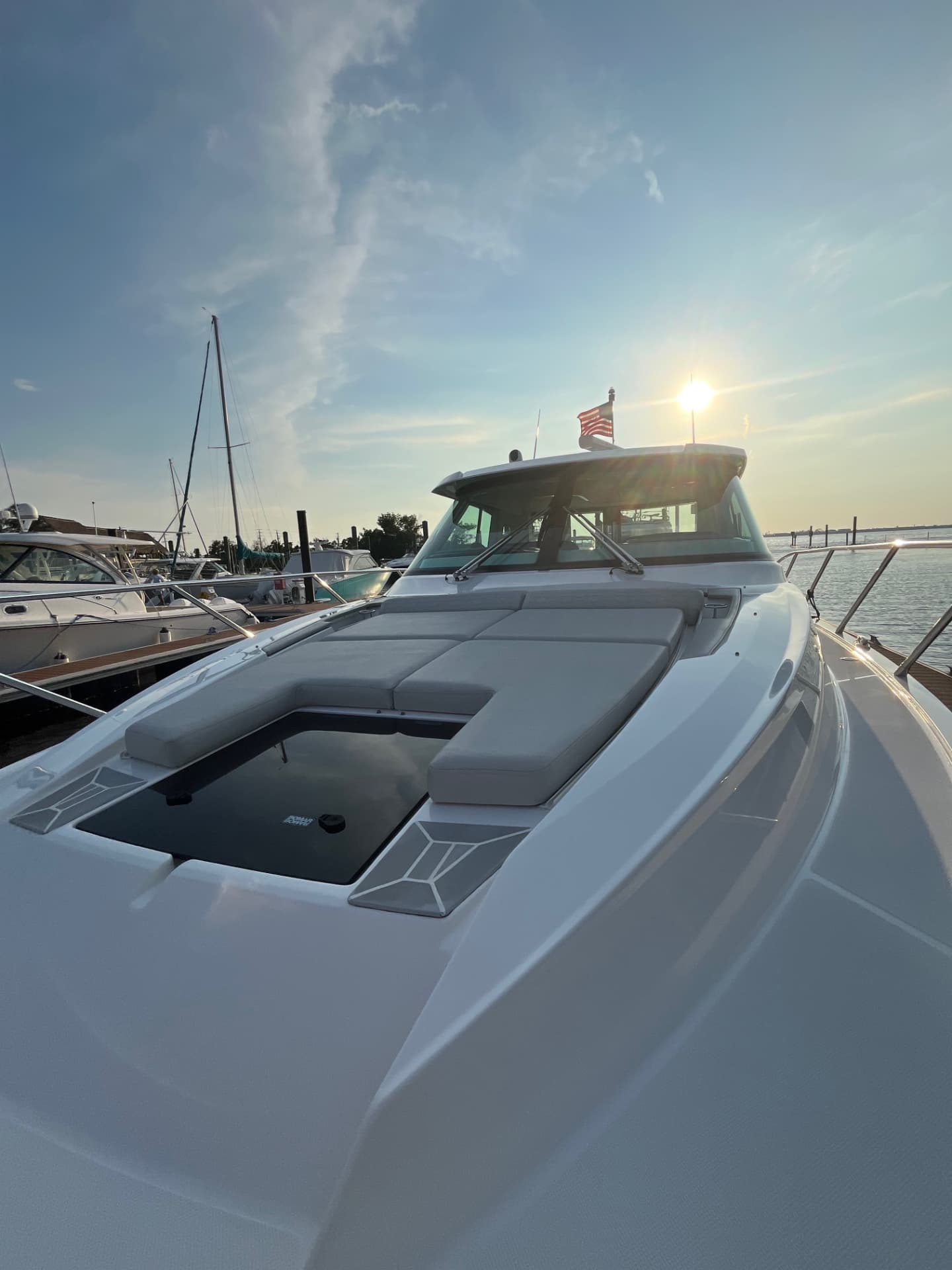 Foredeck, windshield and helm of a client's motor yacht at the dock in late afternoon light