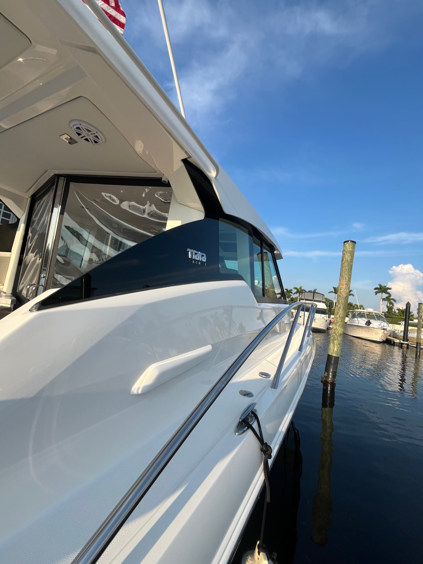 Polished hull, glass and stainless rail of a Tiara yacht afloat at its slip after detailing